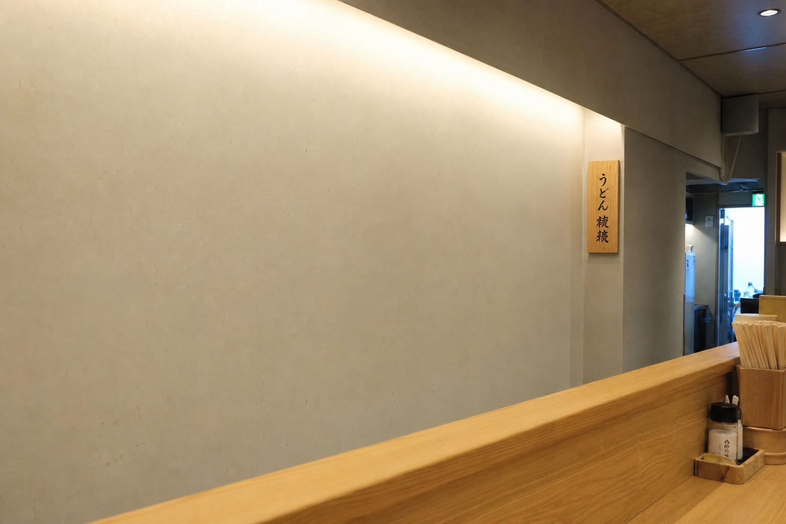 静かな店内の一角。木のカウンターと白壁。