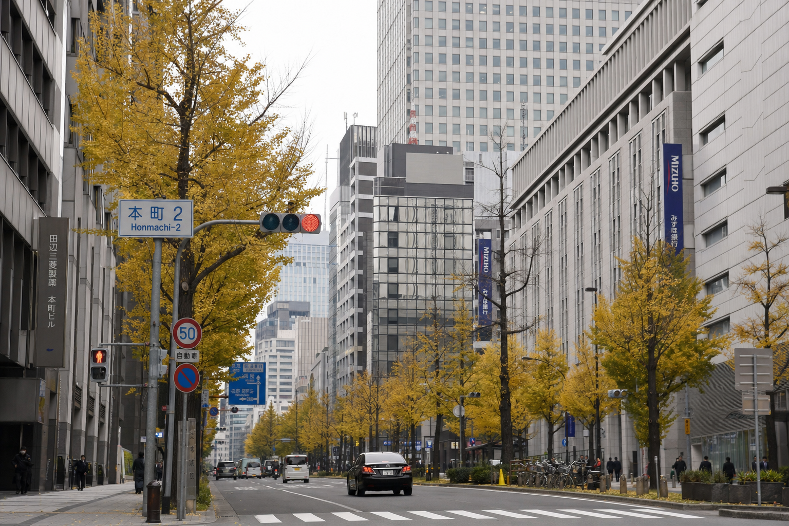 本町のオフィス街。ビルと街路樹の間を歩く昼の風景。